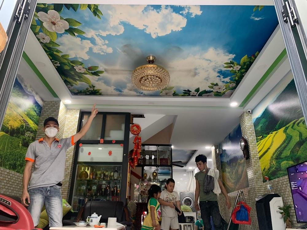 Ảnh thi công tranh dán trần 3D hình bầu trời và giấy dán tường phong cảnh thiên nhiên cho phòng khách.
