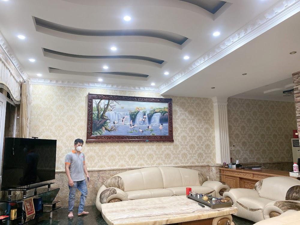 Hoàn thiện bàn giao không gian phòng khách đẳng cấp với mẫu giấy dán tường họa tiết cổ điển hoàng gia tone vàng sáng cực kỳ sang trọng tại Quận Phú Nhuận
