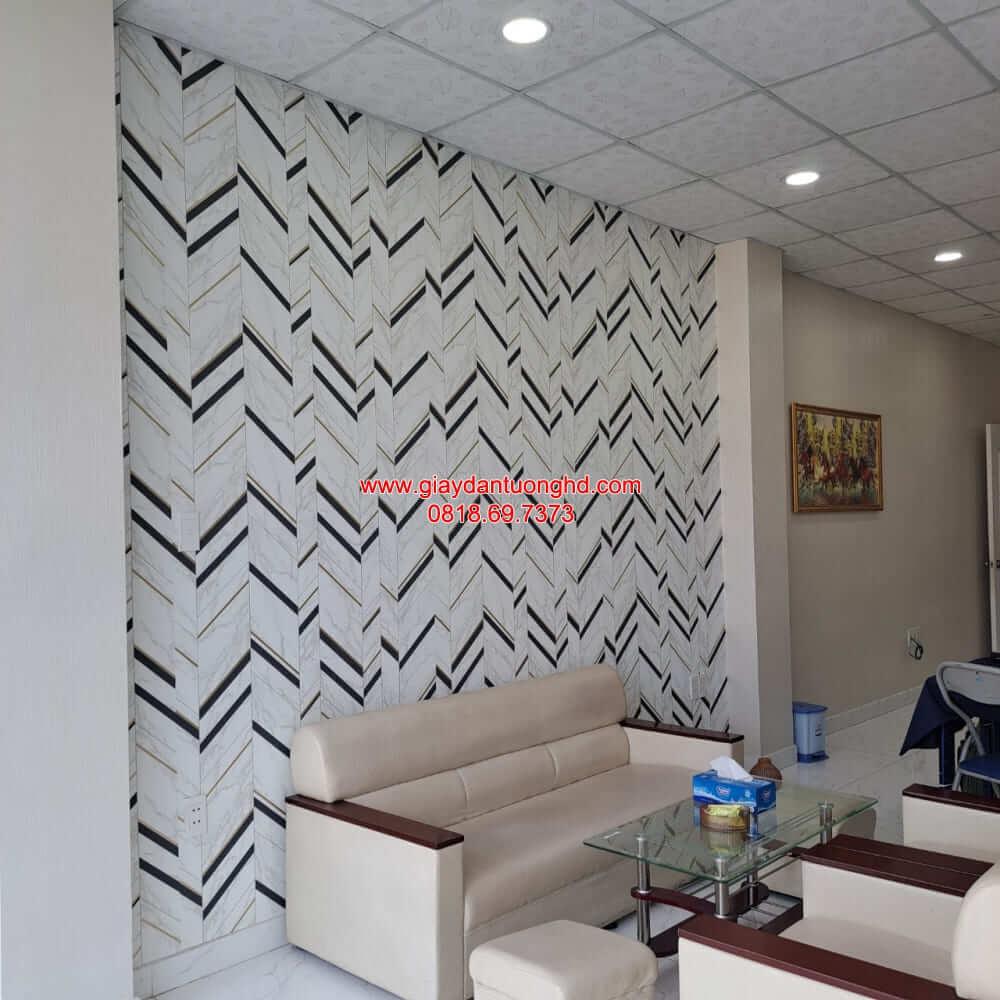 Mảng tường phòng khách sau khi hoàn thiện thi công giấy dán tường họa tiết hình học ziczac xương cá hiện đại phía sau ghế sofa.