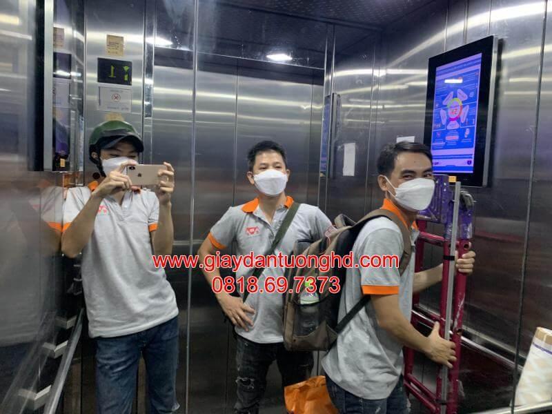 Đội ngũ thợ thi công giấy dán tường chuyên nghiệp vận chuyển trang thiết bị trong thang máy tòa nhà