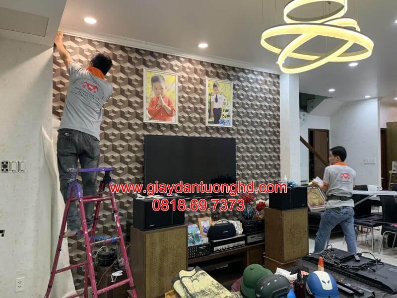 Đội ngũ thợ chuyên nghiệp đang đo đạc và thi công dán giấy dán tường 3D họa tiết hình học cho phòng khách.
