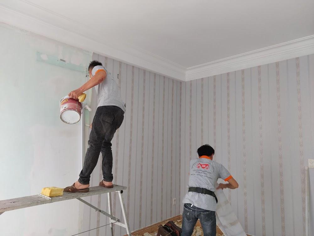 Đội thợ thi công dán giấy dán tường sọc dọc hoa văn tân cổ điển màu hồng nhạt trên giàn giáo
