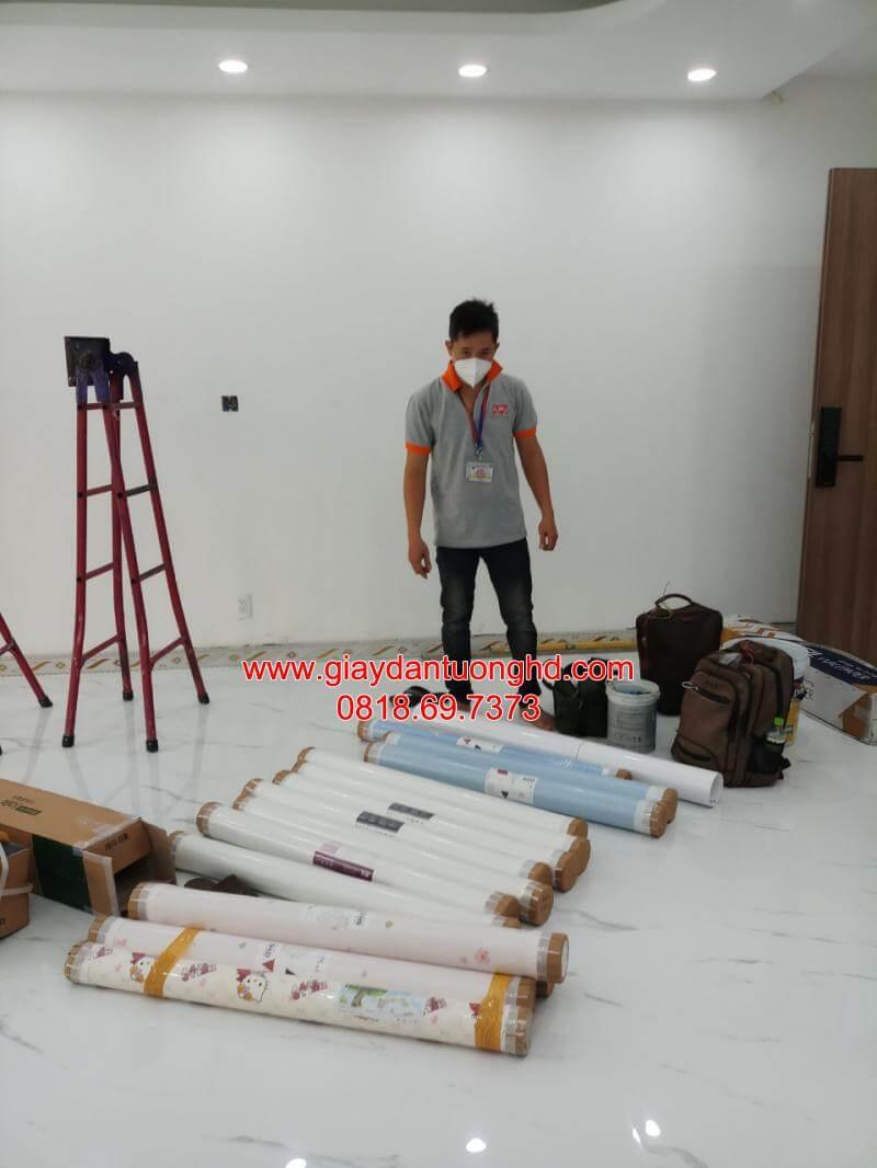 Đội ngũ thợ chuẩn bị vật tư cuộn giấy dán tường và thang nhôm chuyên dụng trước khi thi công tại công trình